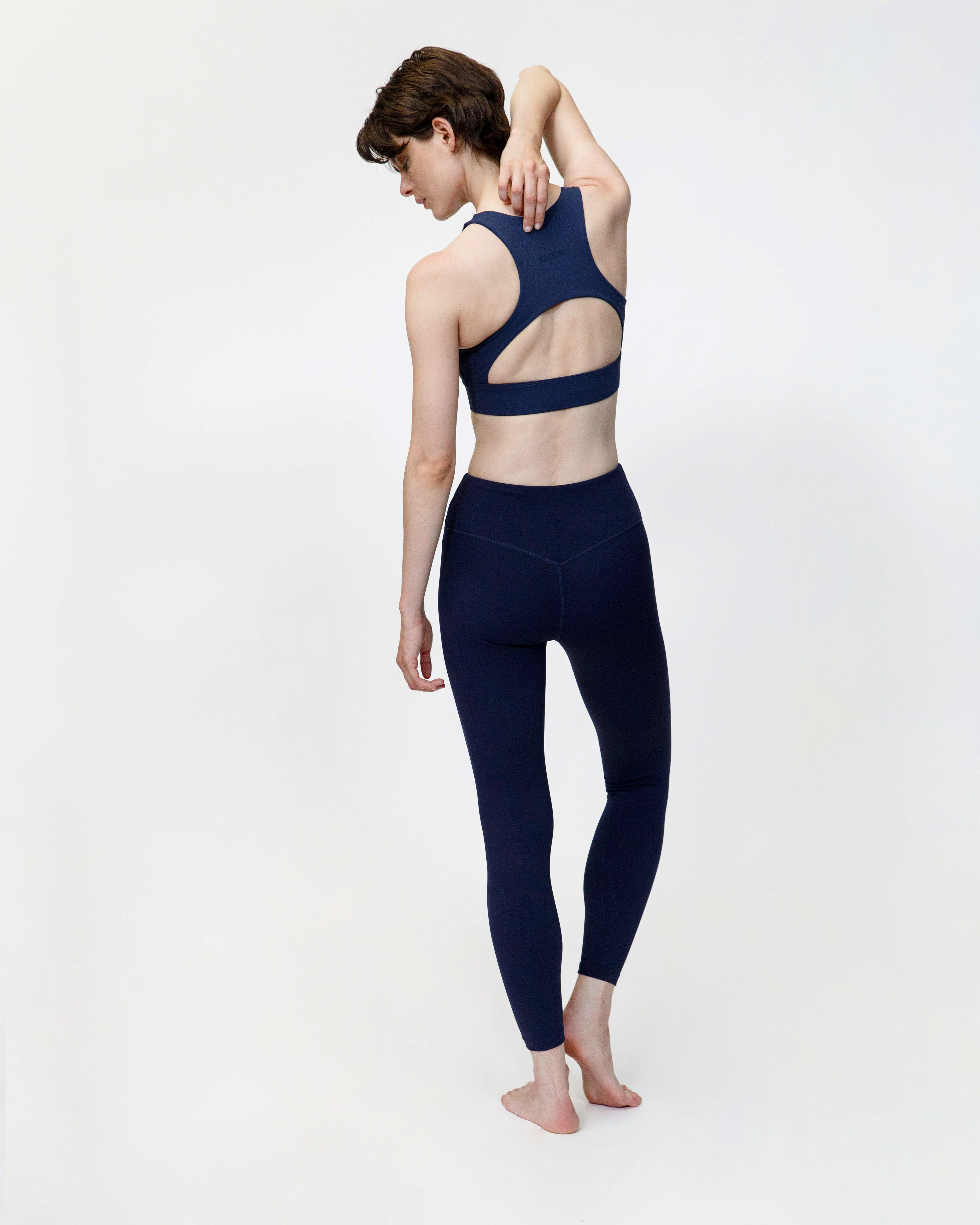 Person wearing a navy blue athletic outfit on a white background