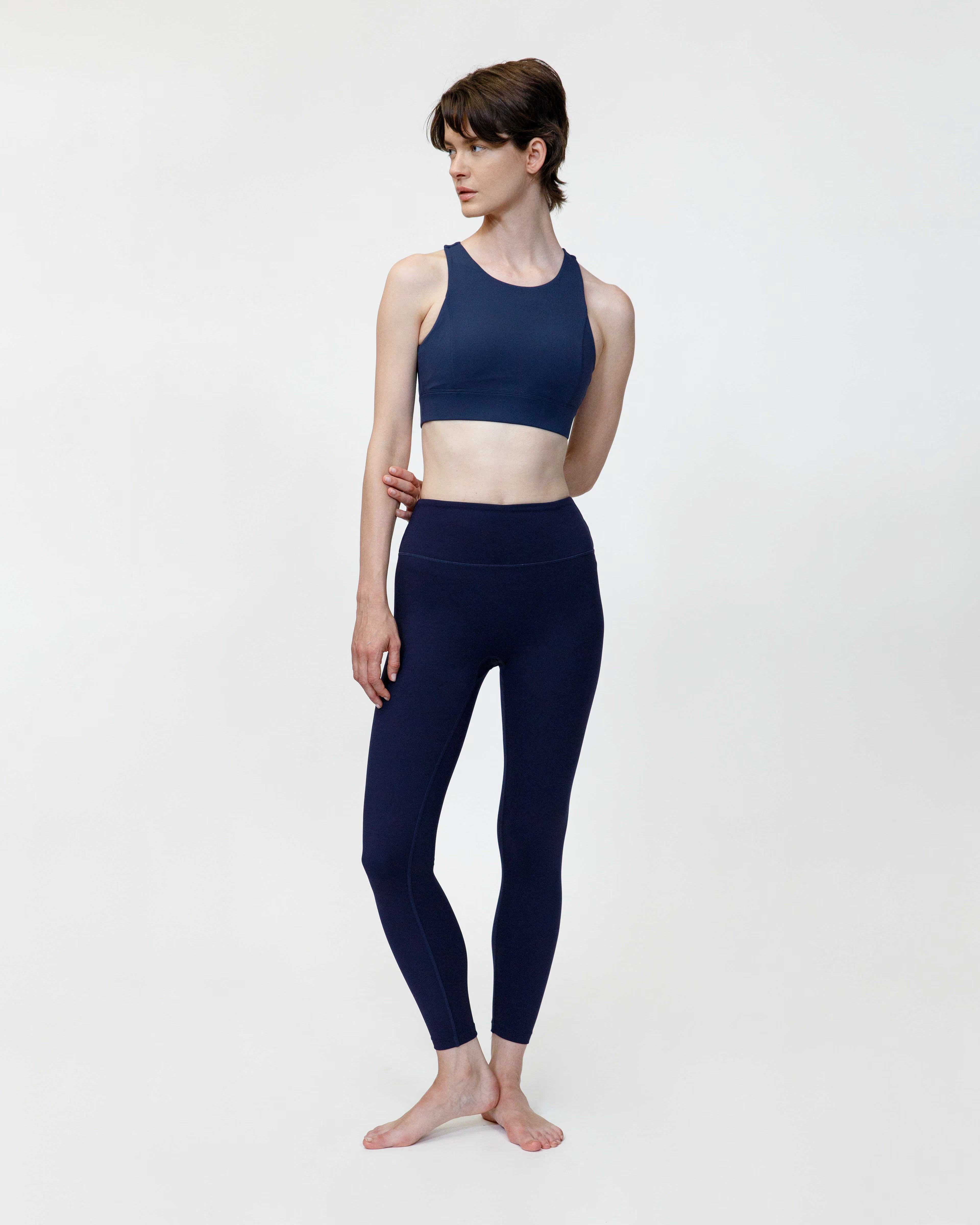 Person wearing a navy blue athletic outfit on a white background