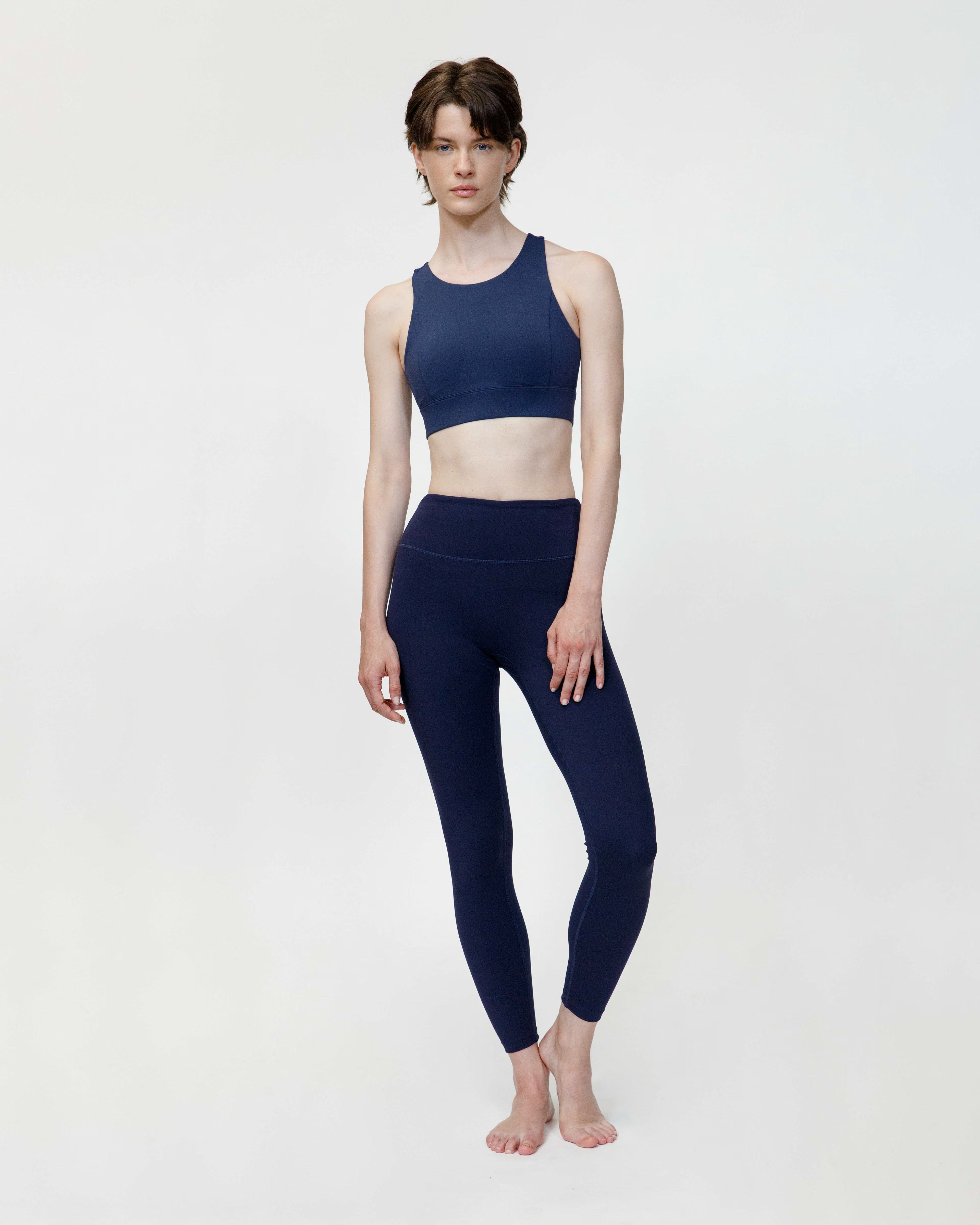 Person wearing a navy blue athletic outfit on a white background